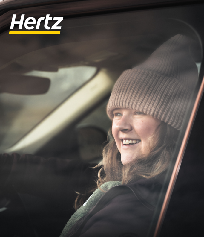 a happy traveler in an Icelandic rental car