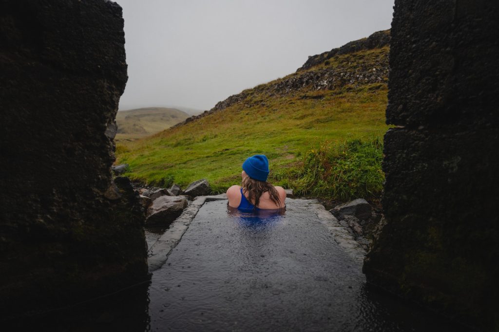 a solo female traveller is enjoying the icelandic natrual hot spring