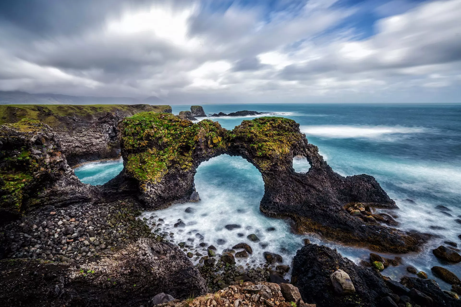 Dramatic basalt cliffs and coastal bridge at Arnarstapi Iceland