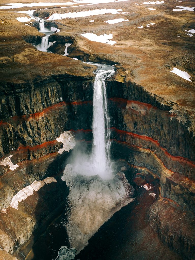 a drone view of the hengifoss waterfall in East Iceland