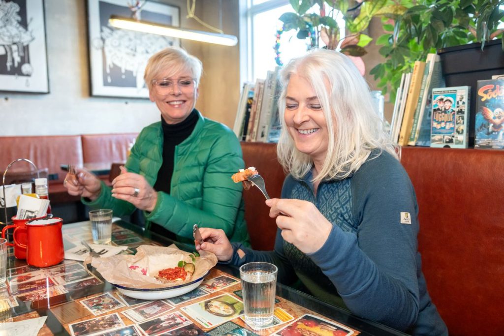 Happy tourists enjoying Icelandic food in Iceland