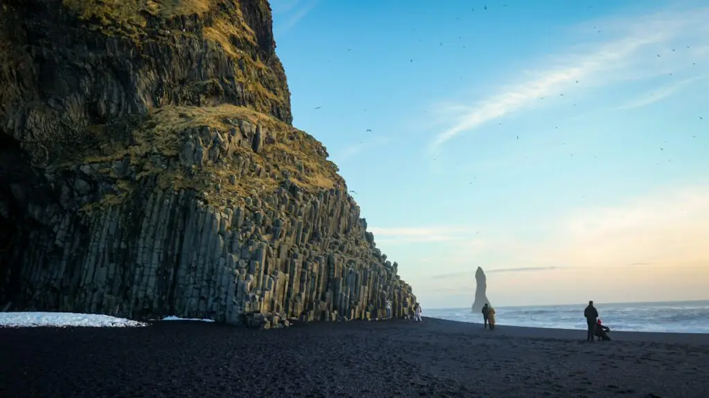 visit the Reynisfjara black sand beach and see the Halsanefshellir cave in Iceland